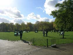 Várias pessoas tomando sol em um parque de Londres