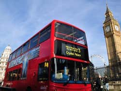 Ônibus de dois andares de Londres passando junto ao Palácio de Westminster