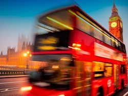 Ônibus percorrendo Londres ao anoitecer