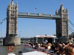Barco navegando pelo rio Tâmisa indo rumo à London Bridge